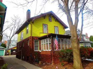 A two-story craftsman house with a wide front porch and no people