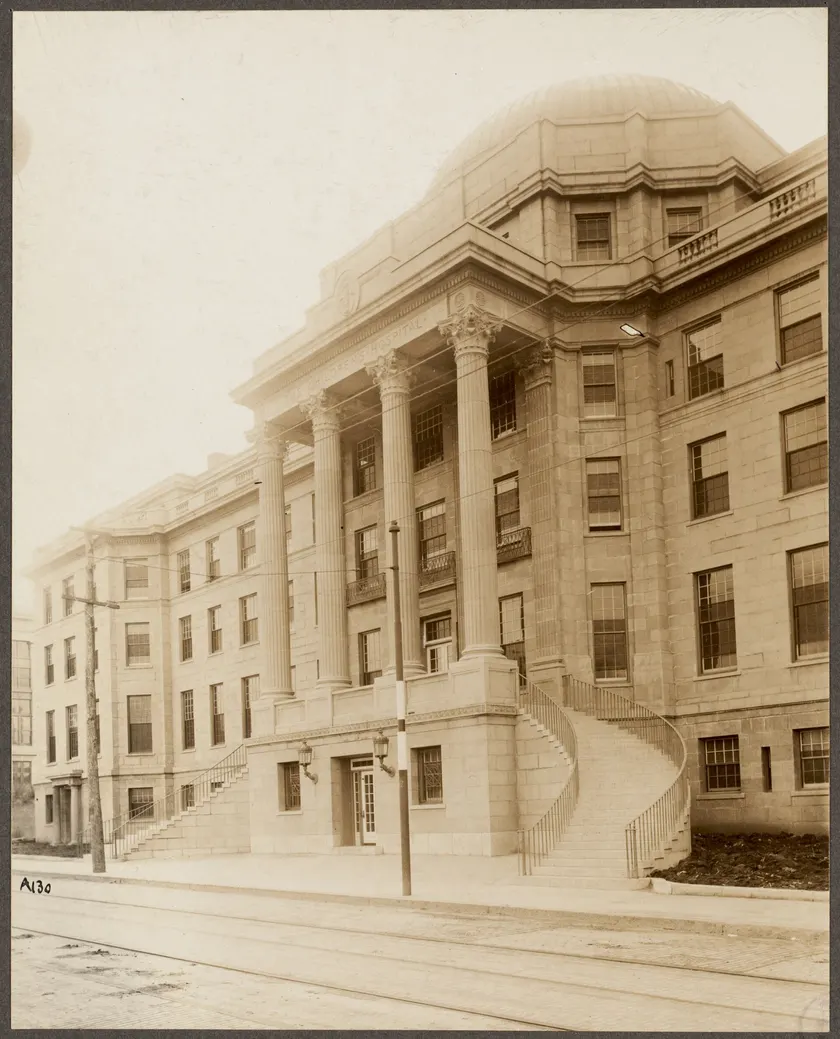 The stone entrance of a historic children's hospital, with a carved sign over the door
