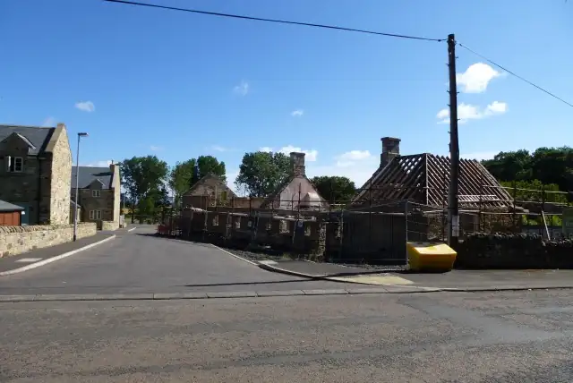 Houses along a street with roof timbers exposed during construction