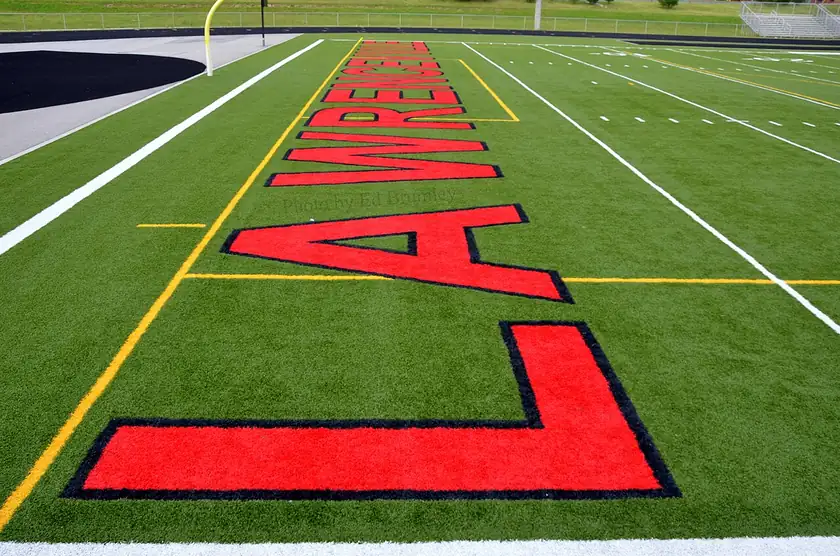 An empty football end zone with the word Tigers painted on the turf and no players on the field