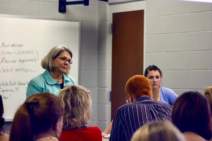 A teacher speaking to students seated in a university classroom