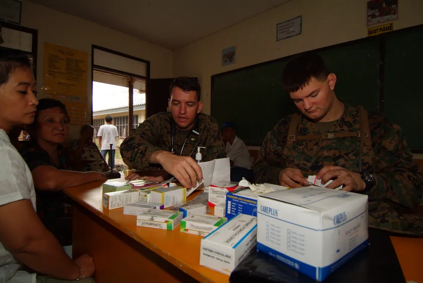Sailors speaking with older adults during a health visit