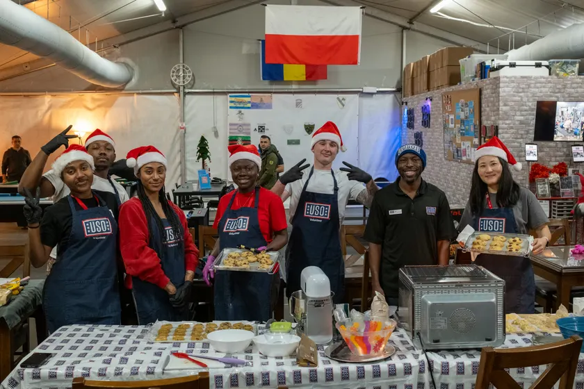 People in a kitchen decorating and packing cookies together