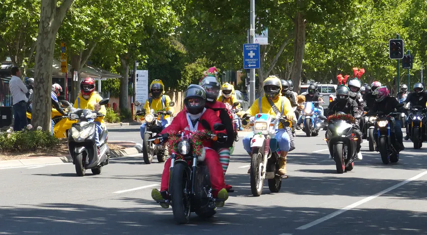 Helmeted motorcyclists riding down a street