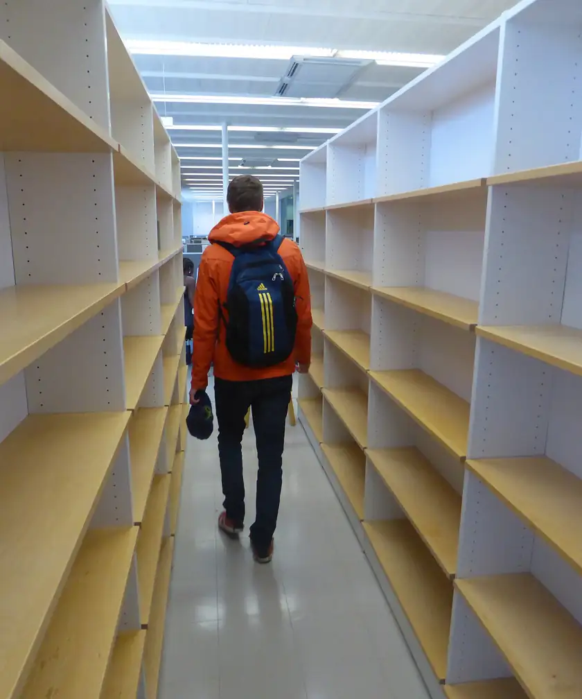 A bright library reading room with bookshelves and no people