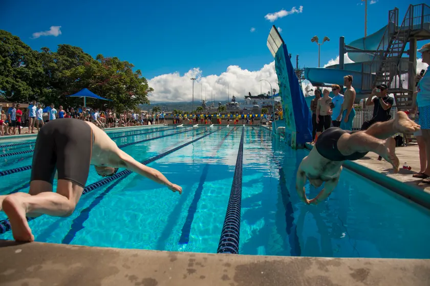 Two swimmers diving into a pool at the start of a race