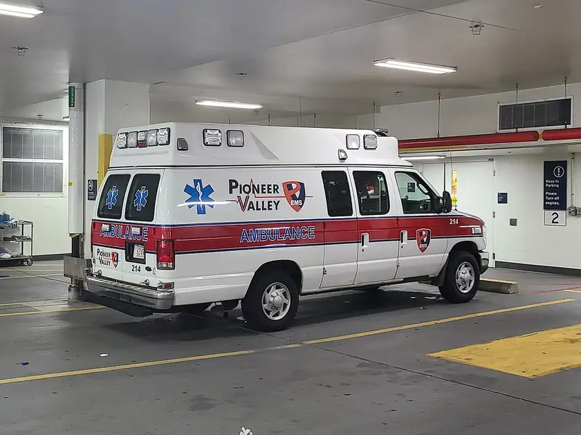 A white and red ambulance parked on pavement