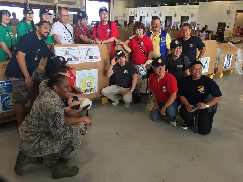 Volunteers in a warehouse sorting boxes of donated supplies