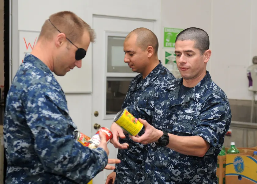 Volunteers sorting canned food in a storeroom