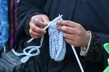 Close view of hands knitting with yarn and needles