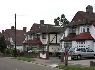 A row of brick semi-detached houses with small front gardens and no people