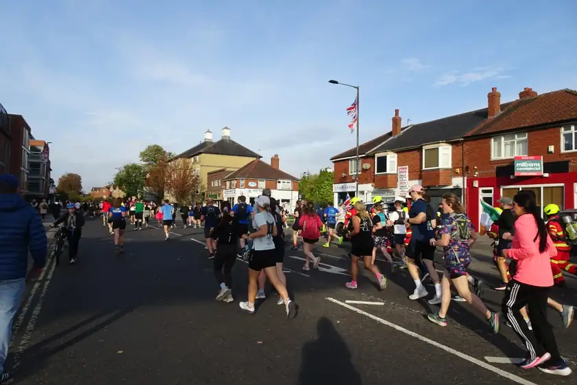 Runners' legs and shoes on a paved road during a race