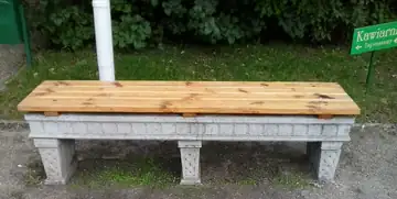 A wooden park bench in a park with no one sitting on it