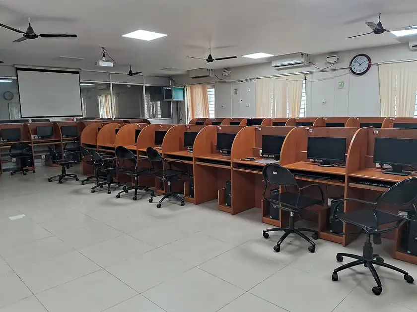 Rows of desktop computers on desks in an empty lab