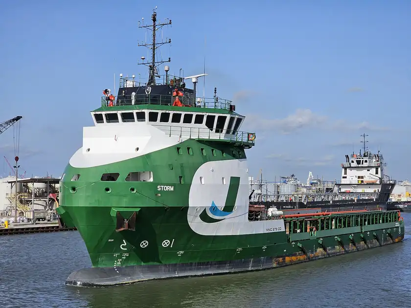 A white and orange offshore supply vessel on open water