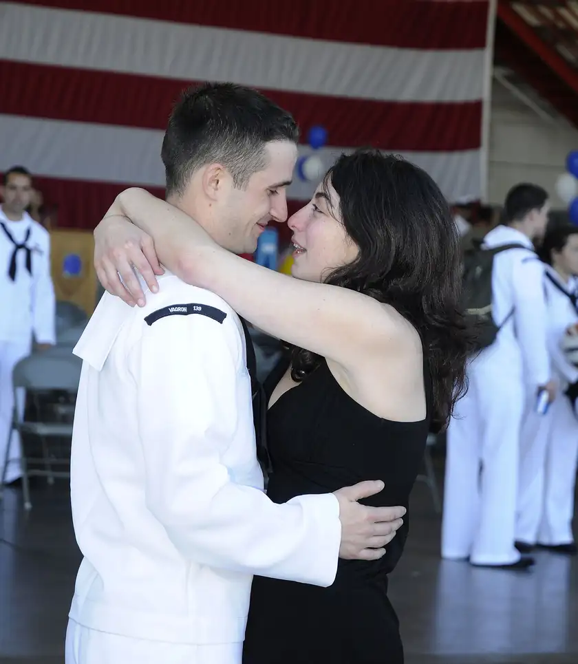 Two adults hugging at a military homecoming