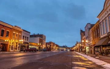 Historic brick storefronts along Second Street in downtown Hastings at dusk