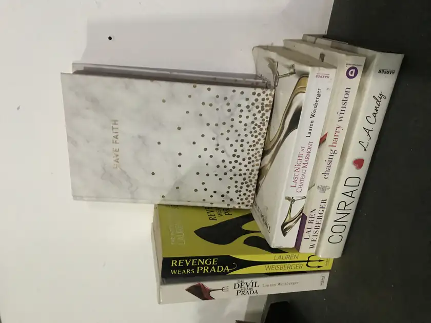 A stack of hardcover books piled on a white surface