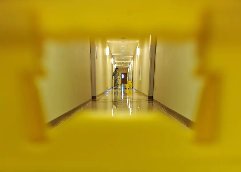 A service member mopping a hallway floor