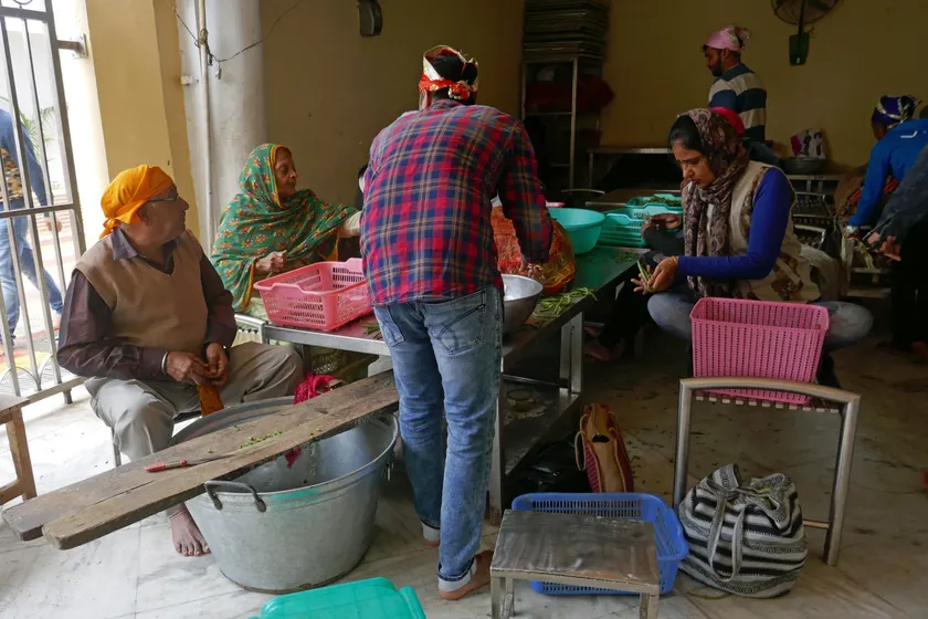 Adults preparing food together in a communal kitchen