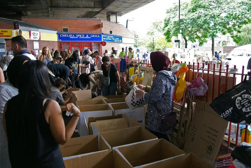 Volunteers in orange vests sorting bags of donated goods