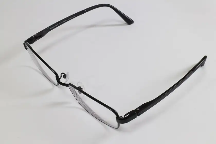 A single pair of black titanium eyeglasses on a white background