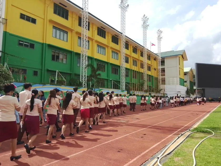 Students walking away from the camera toward a school building
