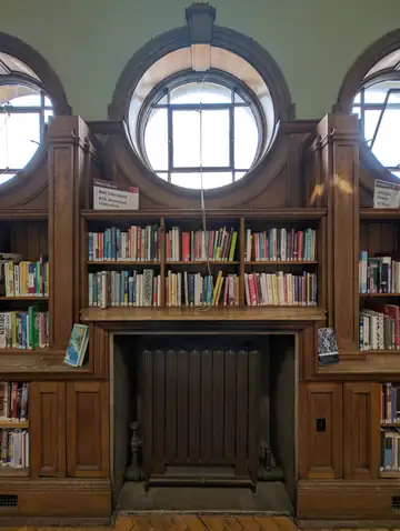 Tall wooden bookshelves filled with books in a library