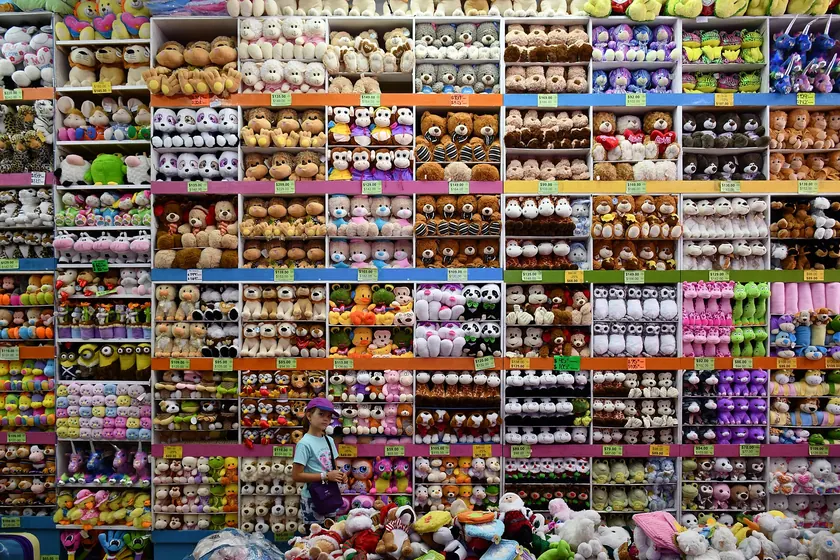 Shelves crowded with colorful plush animals, including tigers, bears, and penguins