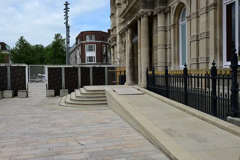 A stone wheelchair ramp leading to the entrance of a stone building