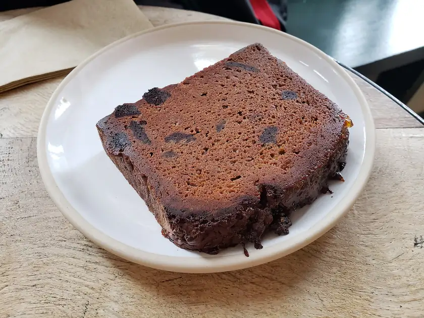 A sliced loaf of banana bread on a metal baking sheet