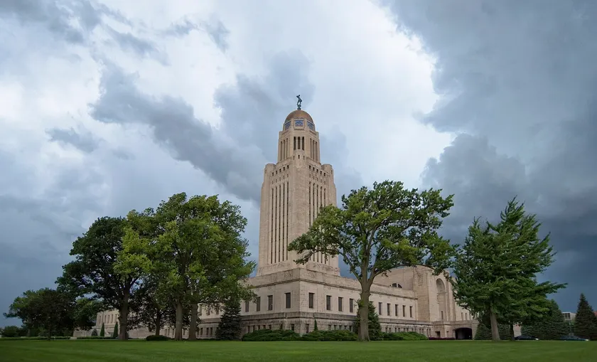 The Nebraska State Capitol tower rising above trees in Lincoln