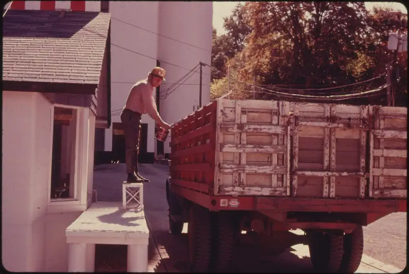 A man checking a truckload of corn at a grain elevator