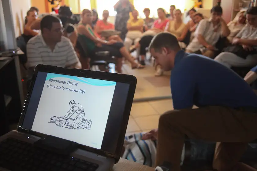 Adults in a classroom practicing first aid on one another