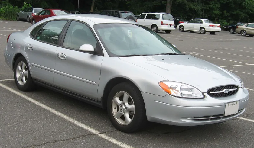A silver Ford Taurus sedan photographed from the front three-quarter angle