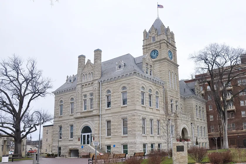 The stone Riley County Courthouse with a clock tower on Poyntz Avenue