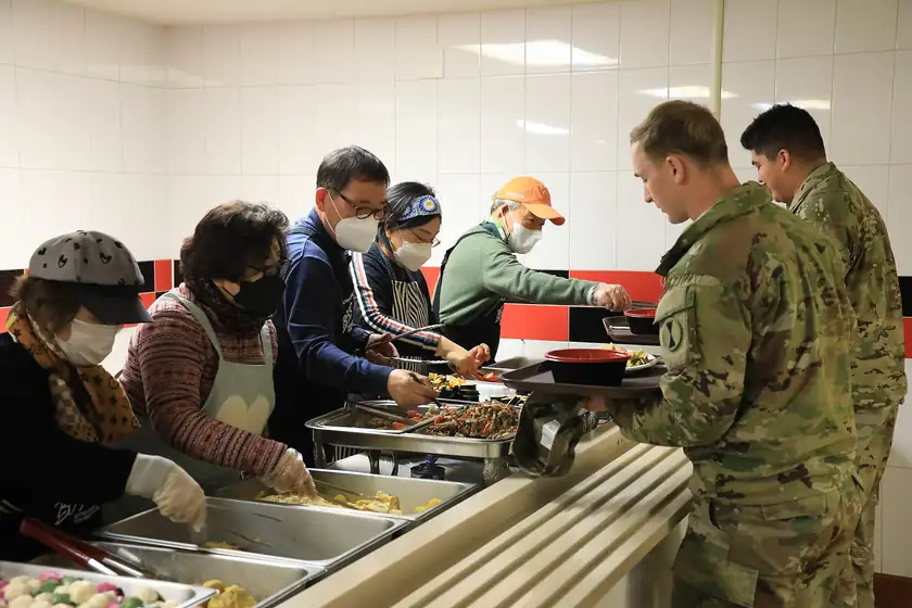 Volunteers in a kitchen preparing a large meal together
