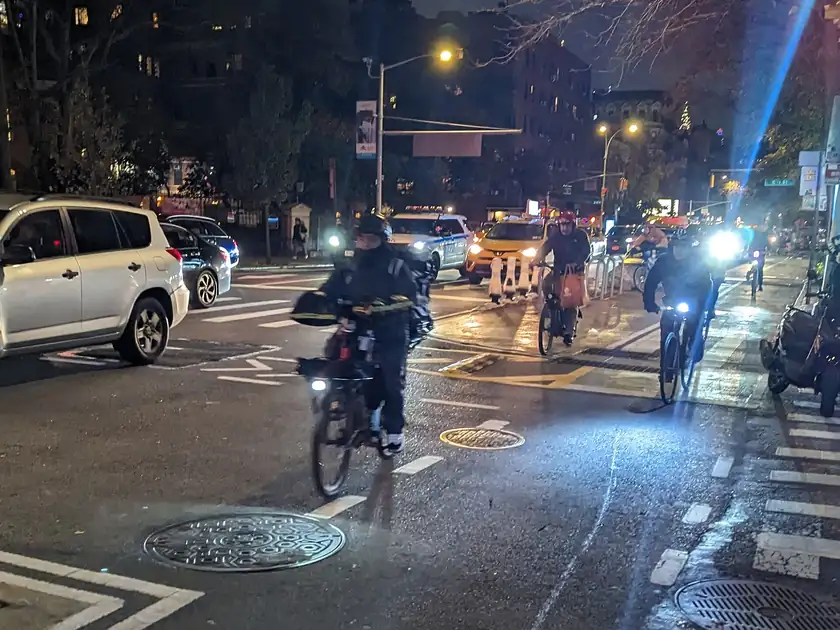 Adults in Halloween costumes riding bicycles on a city street