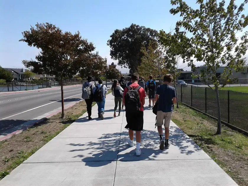 Children seen from behind walking toward a school building
