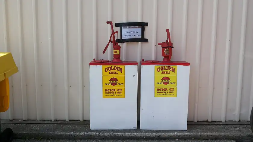 A row of vintage metal motor-oil cans on a shelf