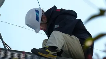 A technician installing solar panels on a rooftop