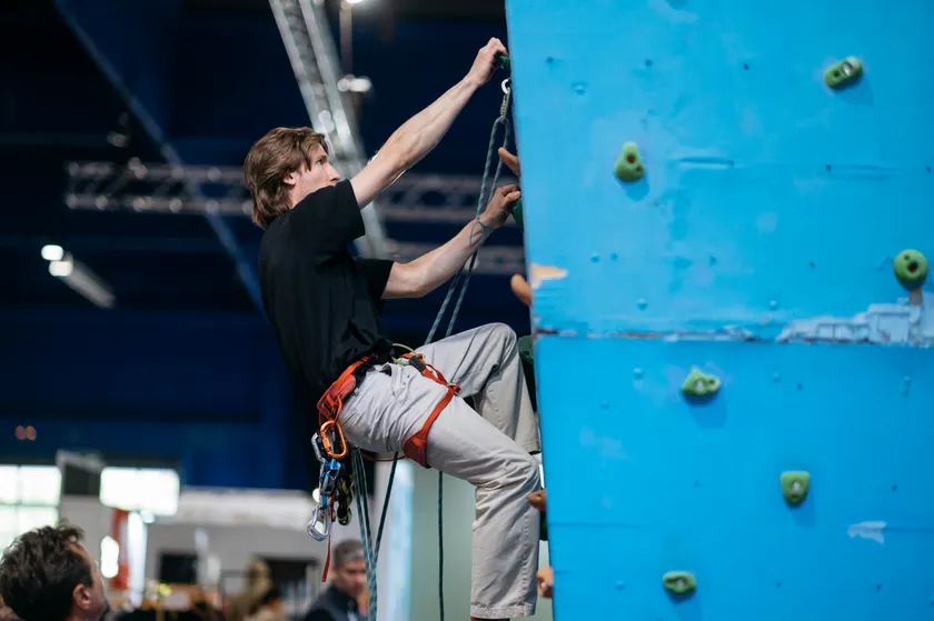 A climber on an indoor wall, secured by a rope