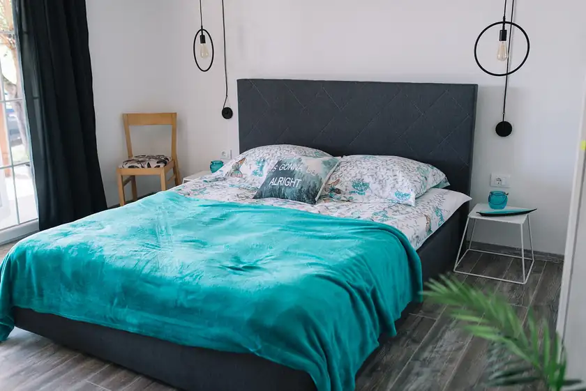 A neatly made bed with white linens in a bedroom, with no people