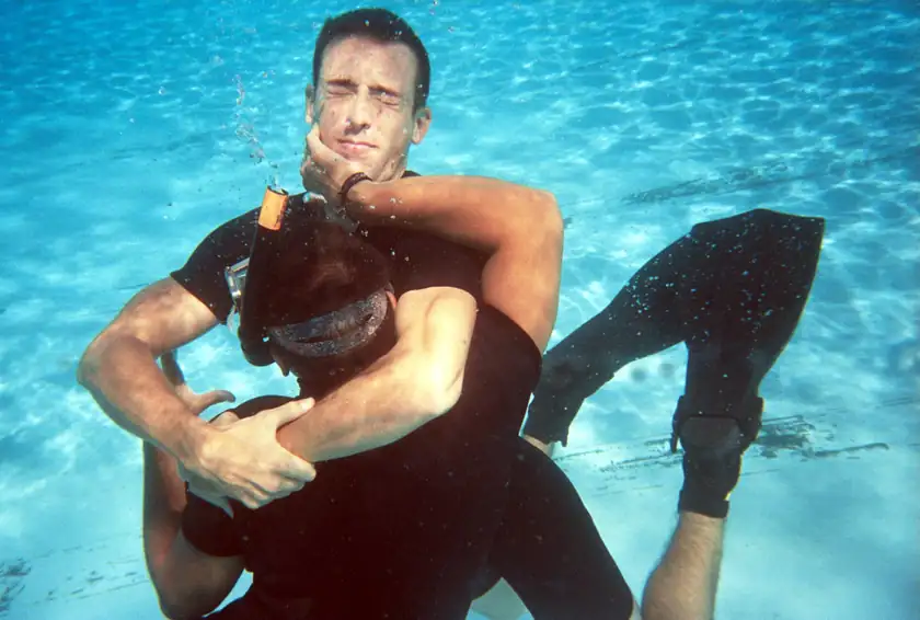 Two adults practicing a water rescue underwater