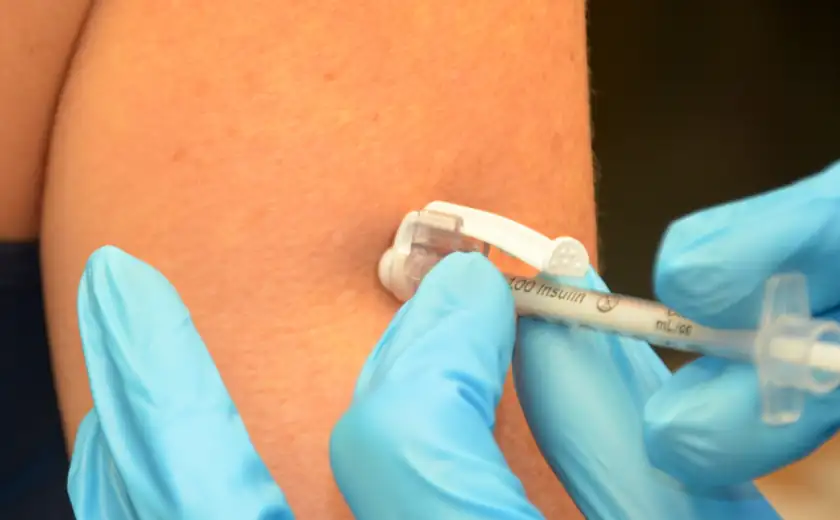 A close-up of an adult abdomen receiving an insulin injection