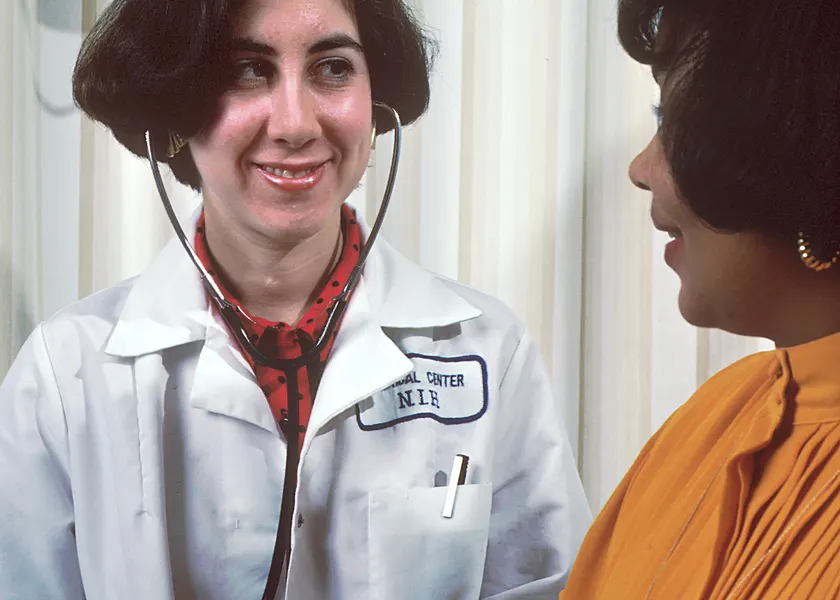 A clinician taking an adult patient's blood pressure