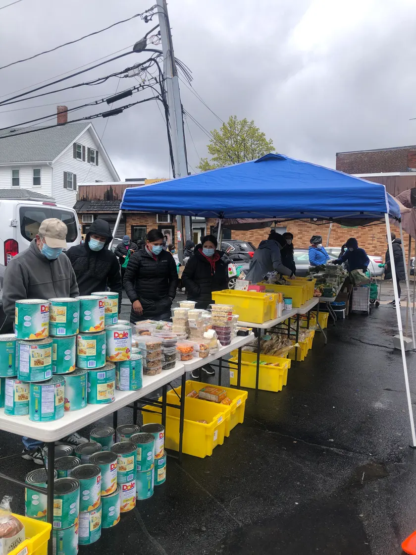 People at an outdoor table handing out canned food and containers