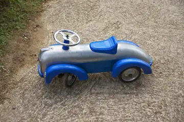 A small blue toy car on a white surface