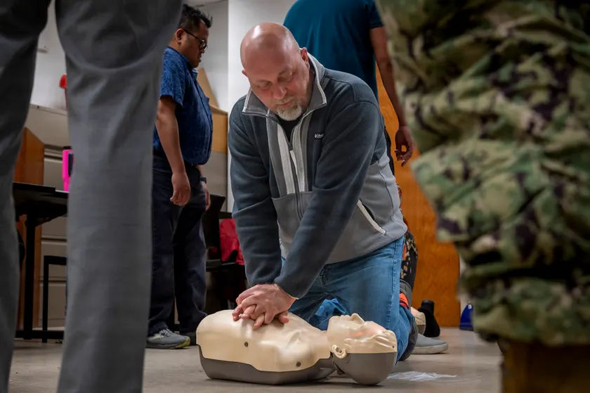 Adults practicing CPR chest compressions on training mannequins