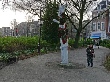 A person walking a path in a park, with a dog nearby